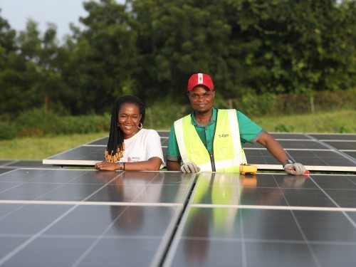 Dos personas beneficiarias de instalación solar fotovoltaica en África, impulsada por Oikocredit.