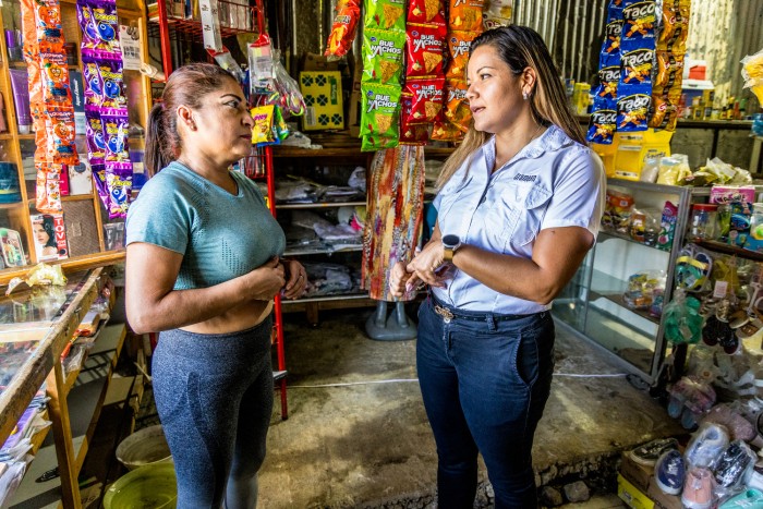 La gerent de Vendes de Grameen, la Kristel Sancho, conversant amb la Karla Patricia Velásquez Carvajal, receptora d'un microcrèdit que va utilitzar per a posar en marxa la seva petita botiga.