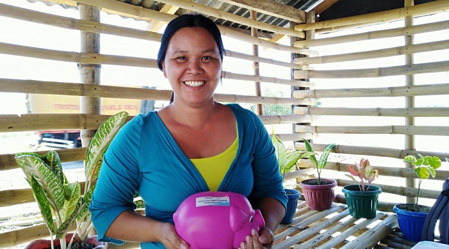 Irene Valdez con su hucha en la que puso ahorros de su pequeña tienda minorista para su proyecto de crianza de cerdos planeado