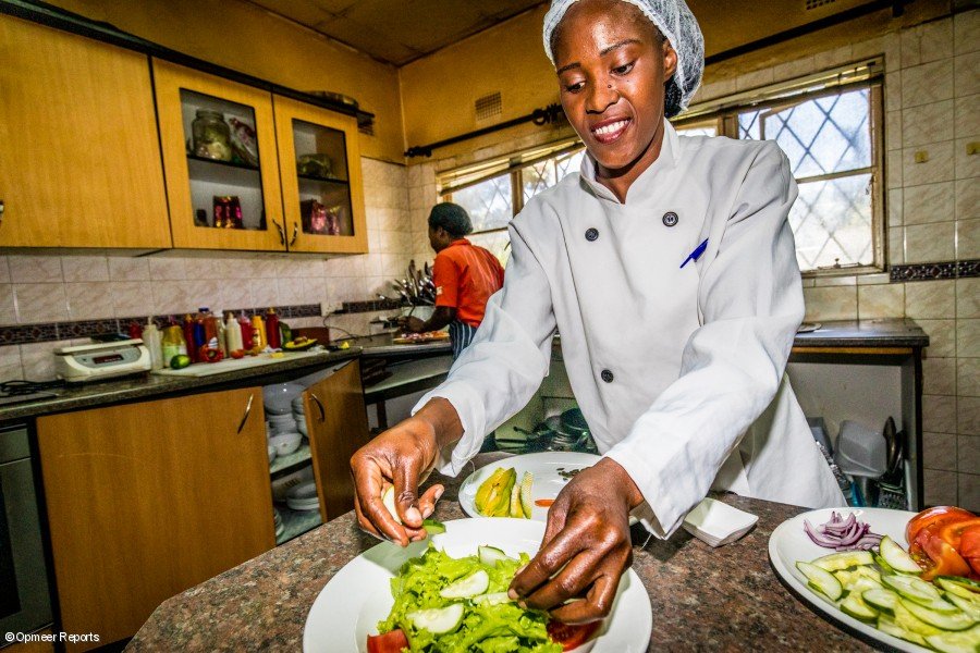 Mercy Kateleshi, sous chef preparando una ensalada en la cocina del restaurante de Jessy Chipindo.